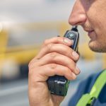 An emergency worker holding a two-way radio up to his mouth getting ready to speak to someone on the other end.