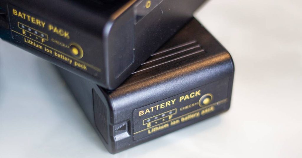  A couple of lithium-ion batteries with black casing that says "Battery Pack" sitting on top of each other.